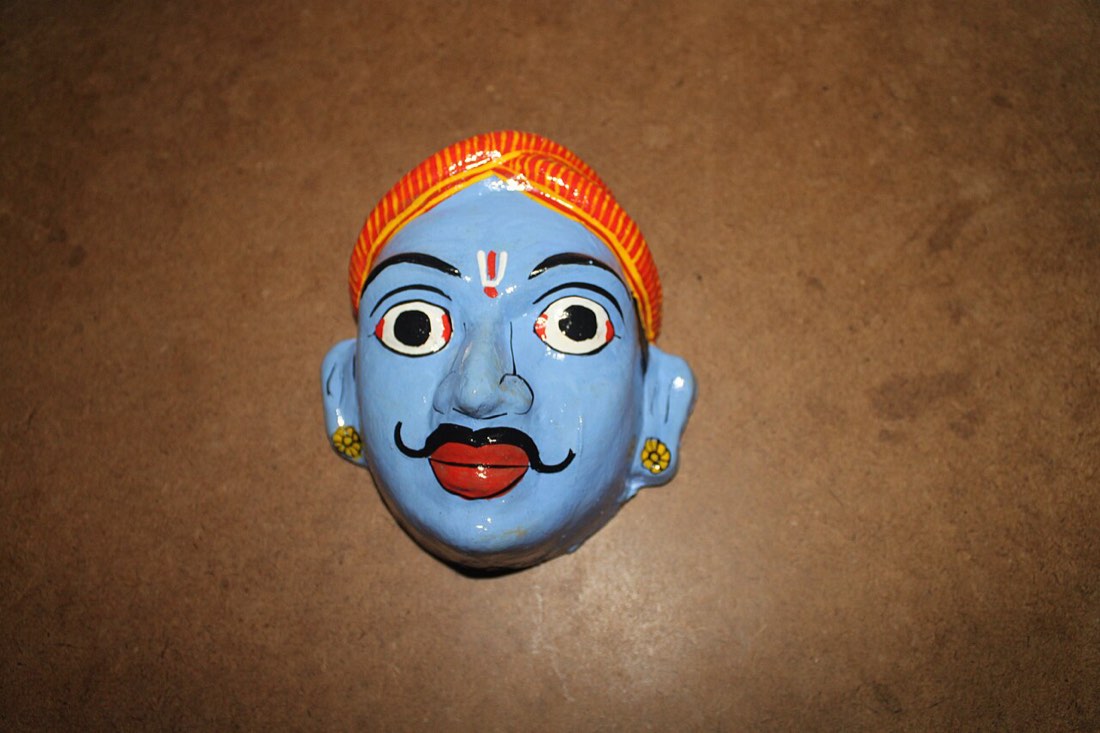 A vivid blue-faced Cheriyal mask, hand-painted in the Nakashi folk tradition of Telangana