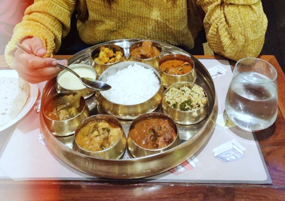 A Telangana thali with rice and an array of curries, dal and pickles in a brass plate